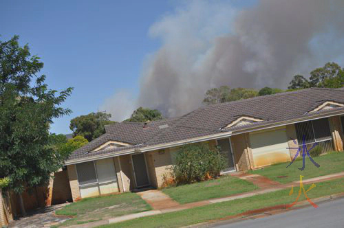 The smoke is from the hills behind the house, not the house itself The smoke is from the hills behind the house, not the house itself