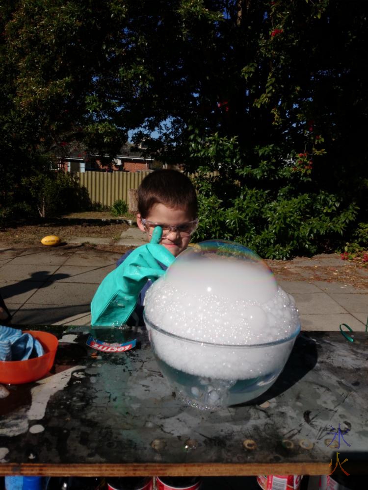 6yo pulling evil scienist face while prepating to pop his giant dry ice bubble