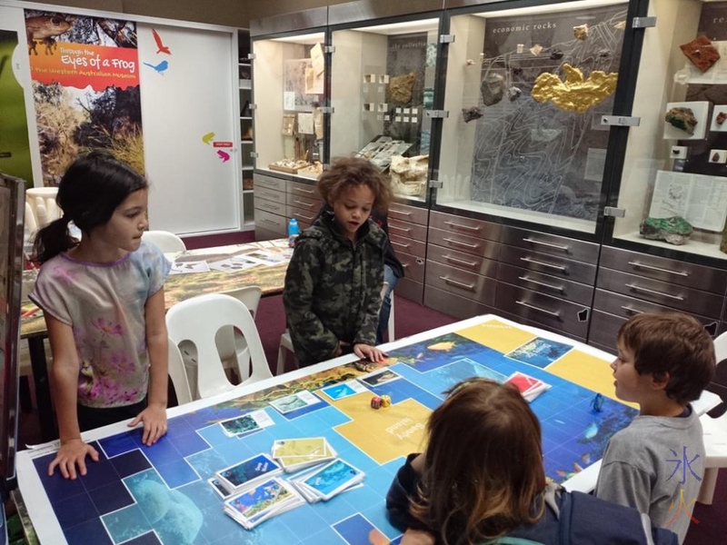 10yo and 8yo playing a board game with friends at the Museum of WA