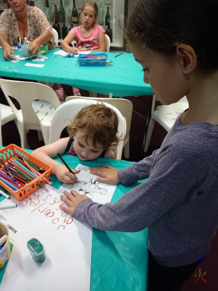 9yo helping the toddler colour in his dinosaur