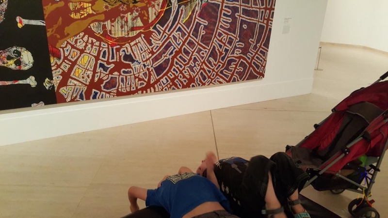 7yo and 3yo trying to understand a picture by getting a different perspective of it (hanging upside down) at Art Gallery of Western Australia