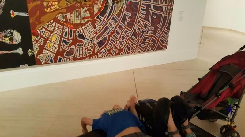 7yo and 3yo trying to understand a picture by getting a different perspective of it (hanging upside down) at Art Gallery of Western Australia