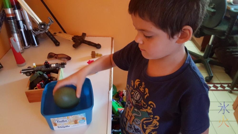 Placing hatching dinosaur egg in a container of water