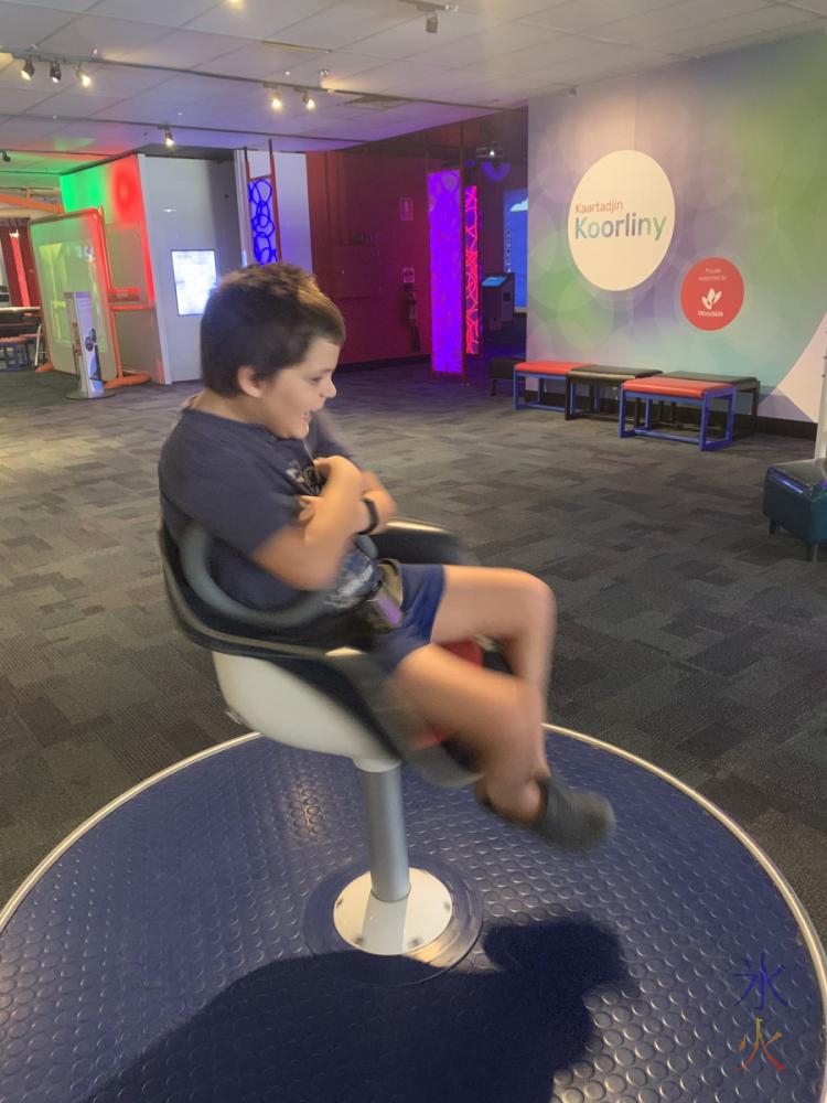 10yo spinning on chair at Scitech, Perth, Western Australia