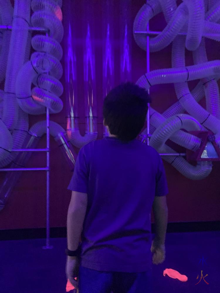 10yo watching scraps of cloth moving through air valve maze at Scitech, Perth, Western Australia