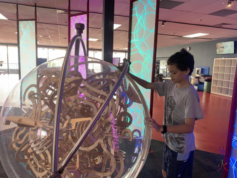 14yo trying to solve giant puzzle ball at Scitech, Perth, Western Australia