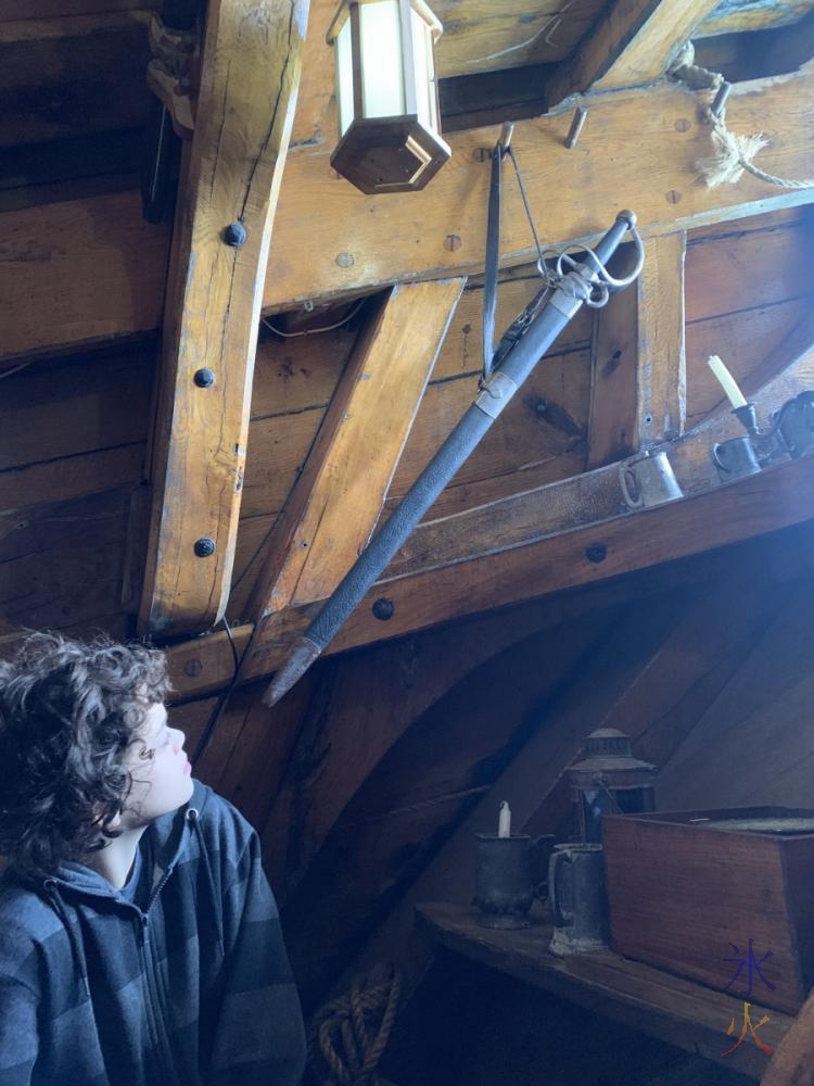 14yo looking at a sword in the captain's cabin aboard the Duyfken replica, AQWA, Western Australia