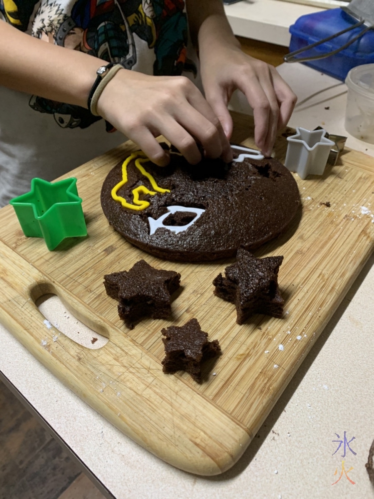cutting shapes out of the cake with cookie cutters