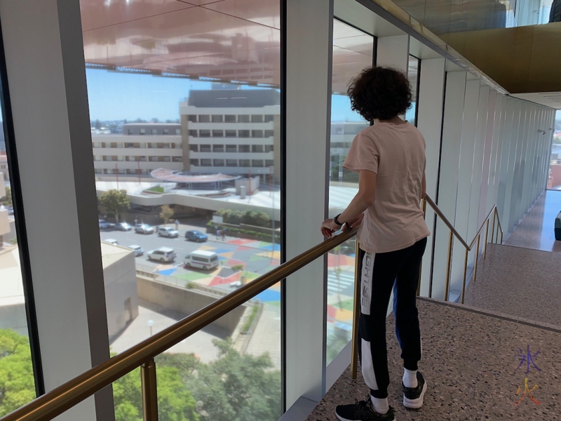 16yo admiring the view from the stair landing going down from third to second floor, Boola Bardip Museum, Perth, Western Australia