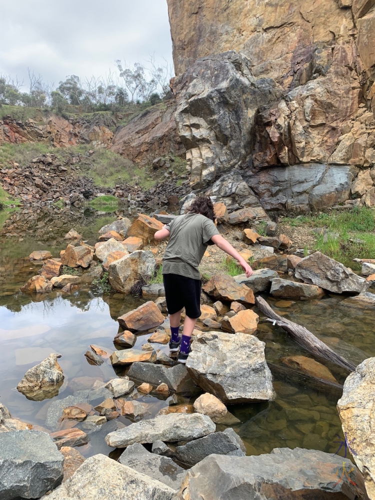 12yo crossing rock bridge in slightly flooded quarry at Ellis Brook, Banyowla Regional Park, Western Australia