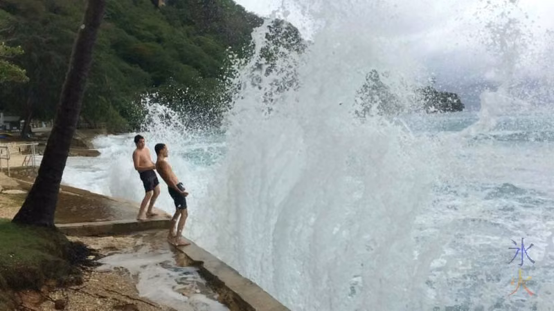 Boys getting splashed by some decent sized waves at Flying Fish Cove, Christmas Island