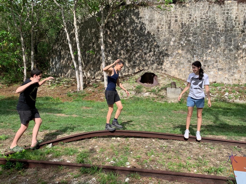 Kids balancing on a railway sleeper at South Point Ruins, Christmas Island