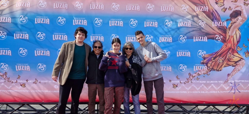 kids and grandparents standing in front of Cirque du Soleil banner