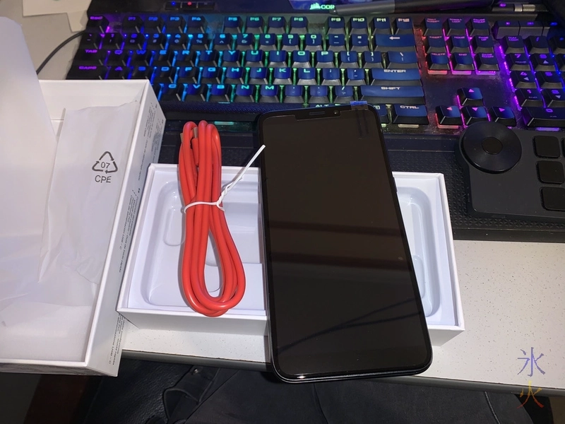 PinePhone Pro and bright red charge cable sitting on top of PinePhone Pro box