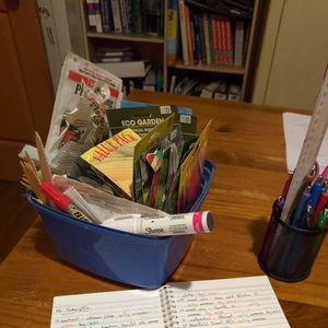 ice cream container full of seed packets, notebook and container full of pens