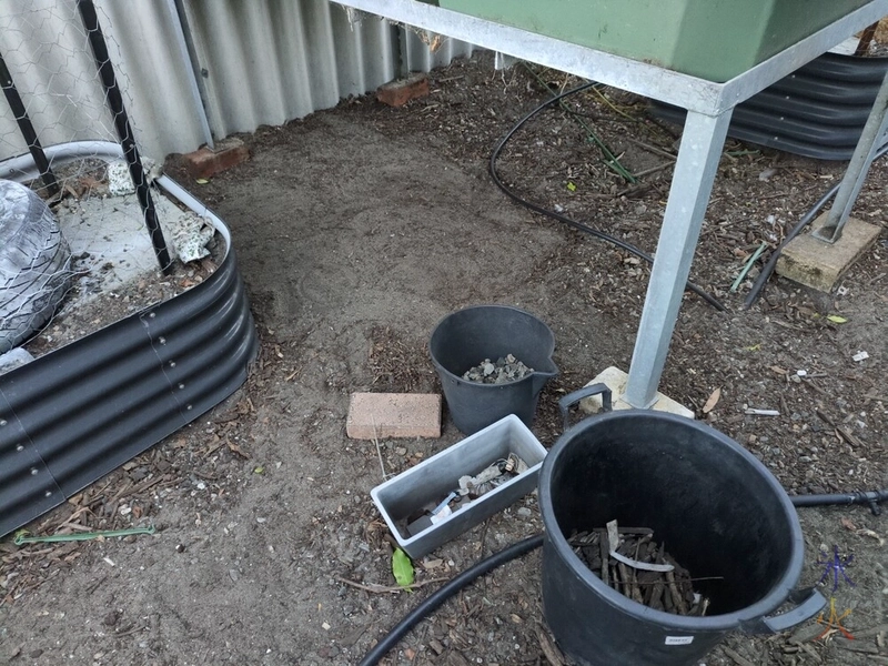 cleared patch of dirt under aquaponics grow bed