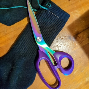 purple sewing scissors and socks with name being stitched on