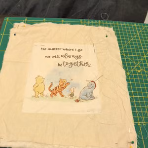 blanket stitching Winnie the Pooh patch to quilt square