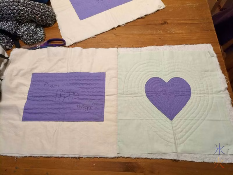 first two quilt blocks in row stitched together with third waiting above