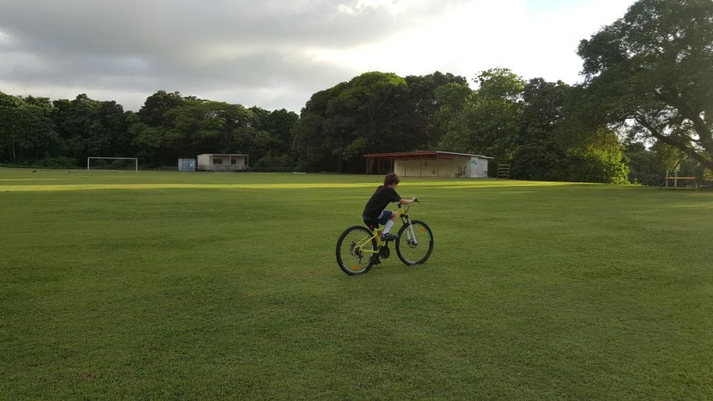 12yo riding bike on school oval, Christmas Island