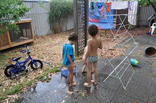 Laundry getting extra rinse while kids play in puddle