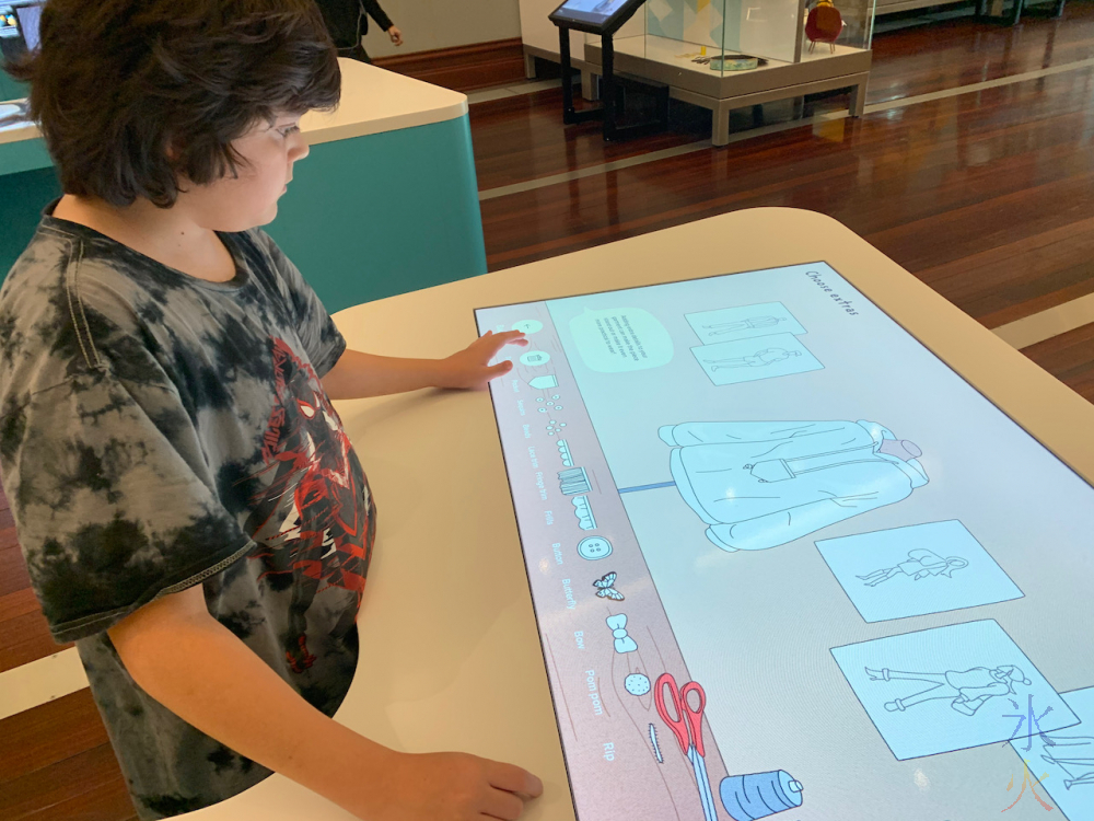 12yo playing with fashion design interactive display at Boola Bardip Museum, Perth, Western Australia