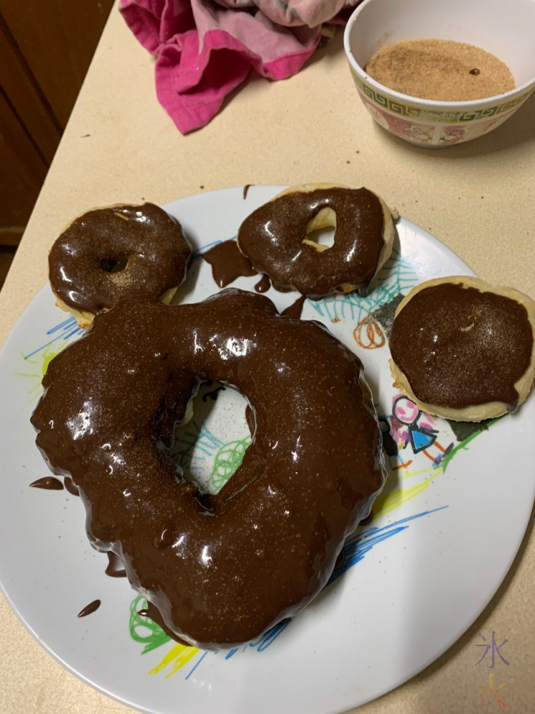 giant dougnut and normal doughnuts covered in chocolate